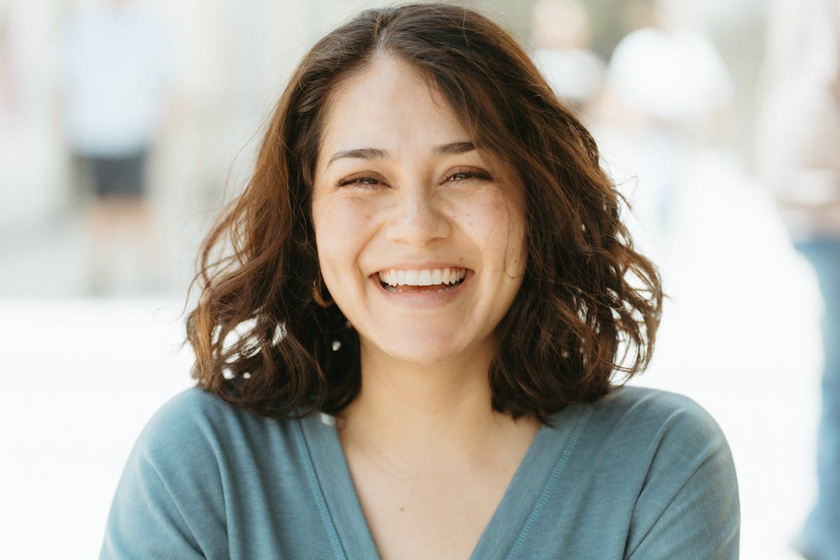 Woman laughing with a healthy smile, enjoying improved chewing and speaking after dental implants in Mesa, AZ