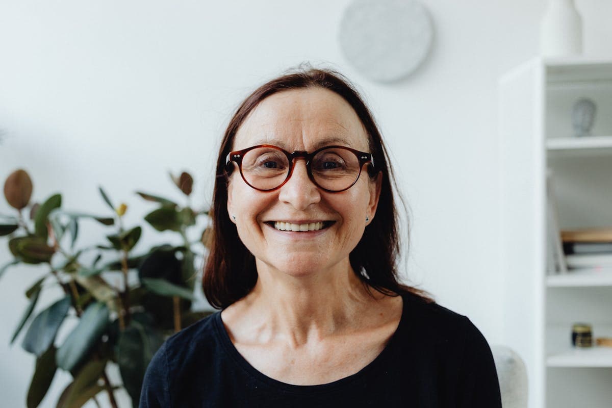 Smiling woman with glasses considering full mouth reconstruction in Mesa, AZ