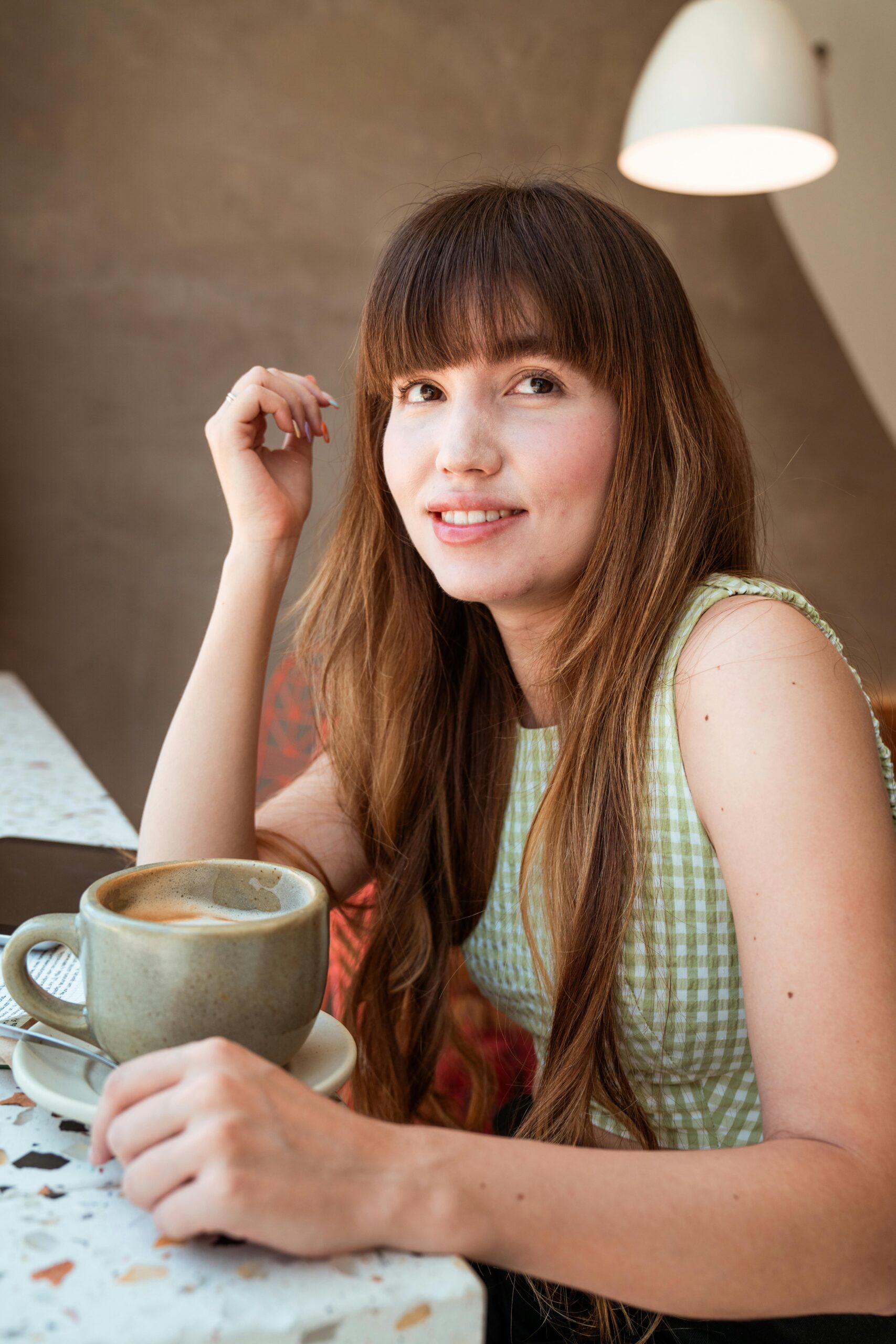 Woman with a bright white smile enjoying coffee after professional teeth whitening at J. Ladd Williams Cosmetic Dentistry in Mesa, AZ