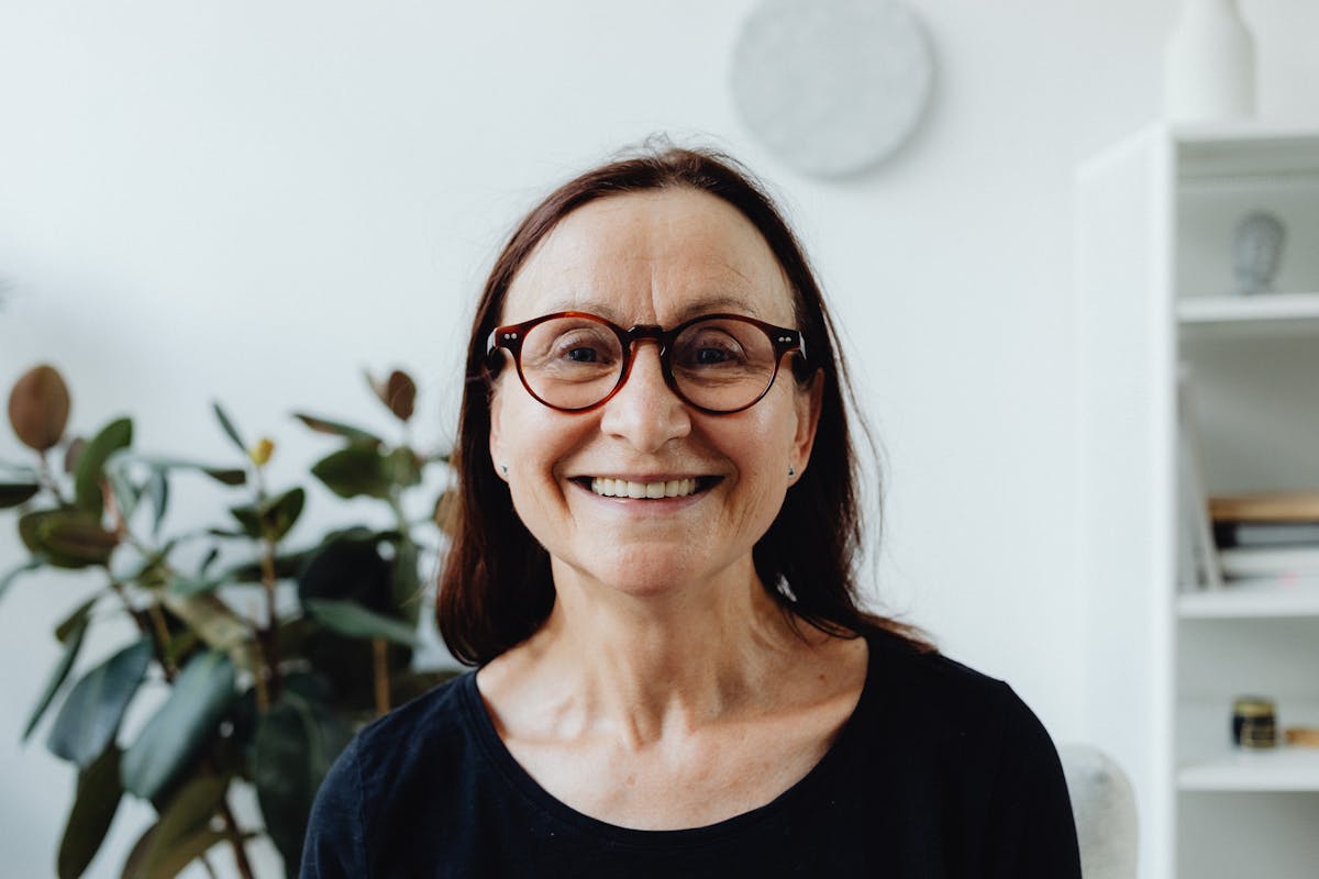 Smiling woman with glasses considering full mouth reconstruction in Mesa, AZ